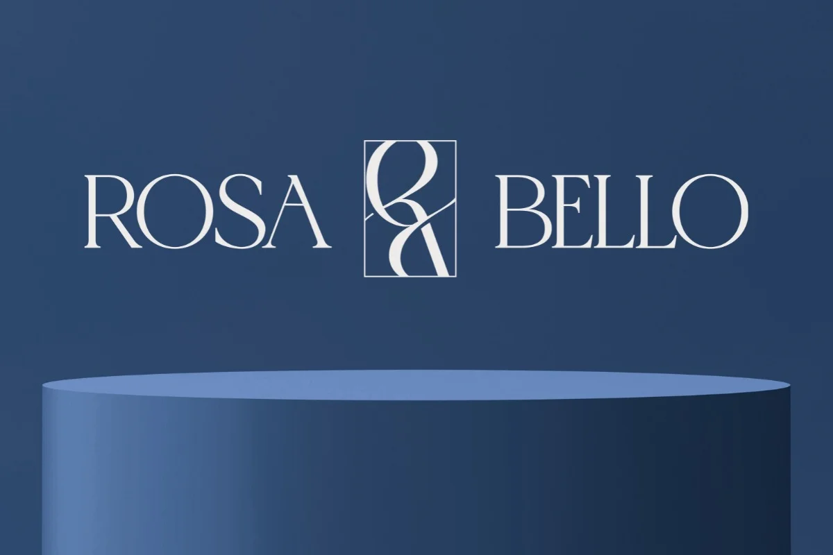The Rosa Bello wordmark — serif capitals flanking the interlocked monogram, white on deep navy above a podium.